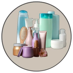 Care collection of various beauty and personal care products including bottles, jars, and a hairbrush.