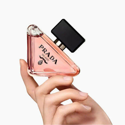Prada Paradoxe Eau De Parfum For Women 90ml bottle held in hand, showcasing its elegant triangular design.