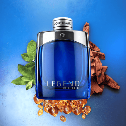 Montblanc Legend Blue Eau De Parfum bottle with wood, mint, and amber elements against a blue background.